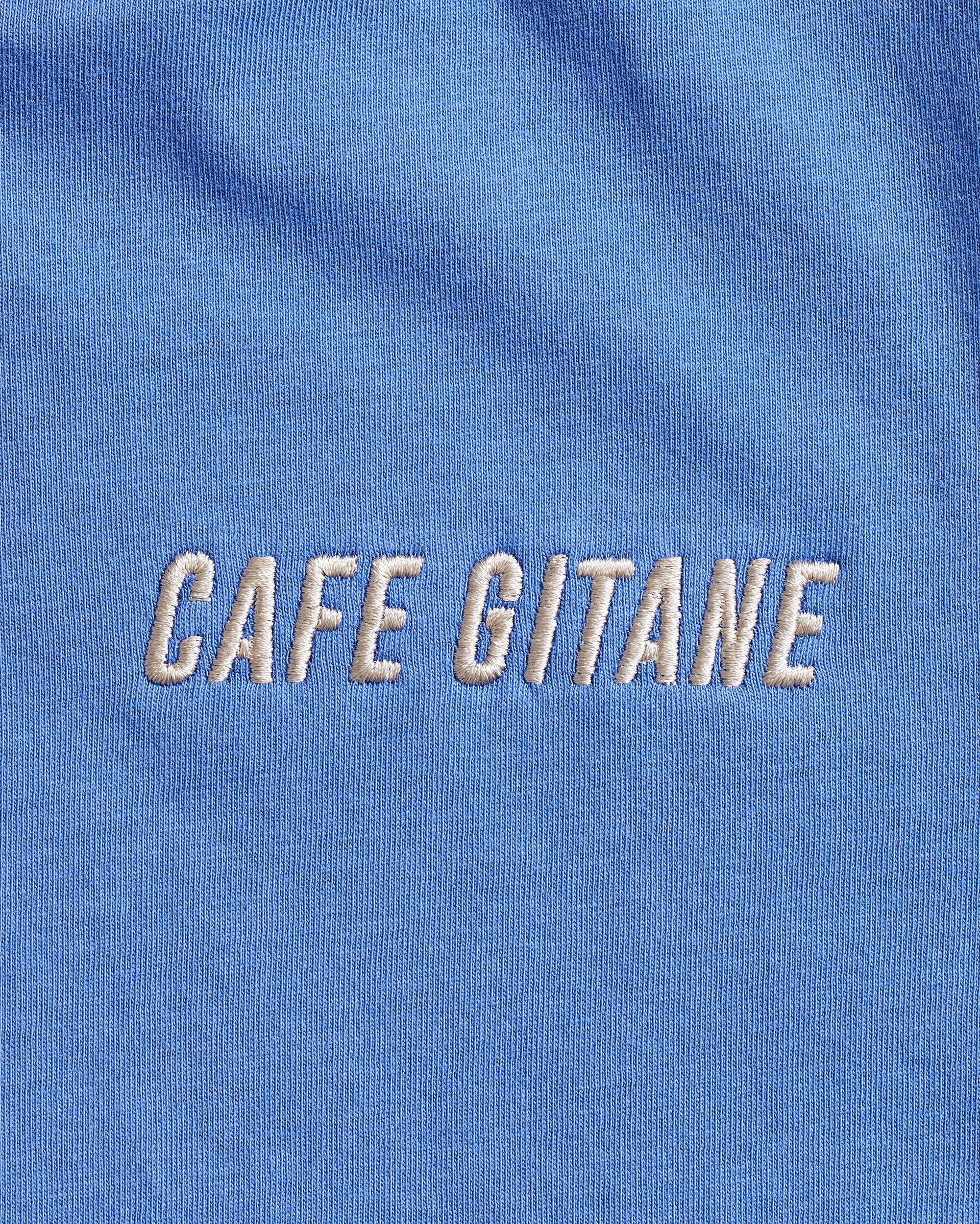 The Cafe Gitane Vintage Wash Embroidered Tee is 100% ring spun cotton and made in the USA. The classic t-shirt in sky blue is embroidered on the left chest in a silver-gray thread. The t-shirt is pigment dyed which means that it has a sublet vintage look and will get more wash the older it gets.