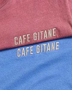 The Cafe Gitane Vintage Wash Embroidered Tee is 100% ring spun cotton and made in the USA. The classic t-shirt is available in red clay and sky blue is embroidered on the left chest in a silver-gray thread. The t-shirt is pigment dyed which means that it has a sublet vintage look and will get more wash the older it gets.